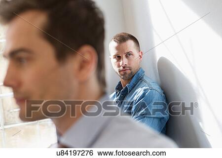 Mid adult man wearing denim shirt, man in foreground View Large Photo Image Stock Photograph - Mid adult man wearing denim shirt, man in foreground. Fotosearch