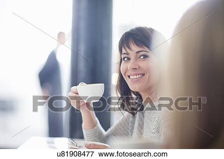 Stock Photo - Mid adult woman in cafe with coffee. Fotosearch
