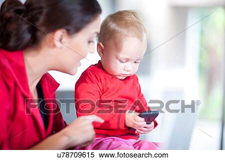 Stock Photography - Mother and daughter with cell phone. Fotosearch