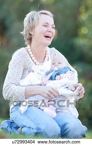 Mother holding baby daughter, laughing View Large Photo Image Picture - Mother holding baby daughter, laughing. Fotosearch