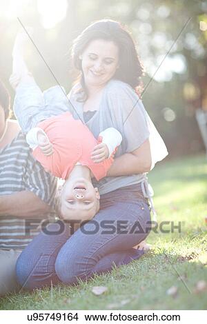 Mother holding son upside down View Large Photo Image Picture - Mother holding son upside down. Fotosearch