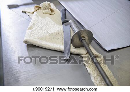 Stock Image - Offcut of dough, knife and rolling instrument in bakery. Fotosearch