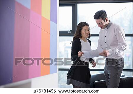 Office workers discussing notes together View Large Photo Image Stock Photography - Office workers discussing notes together. Fotosearch