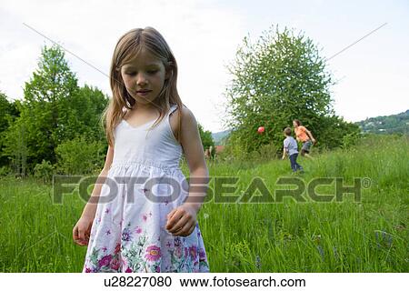 Stock Image - Outdoor portrait of young girl in floral dress. Fotosearch