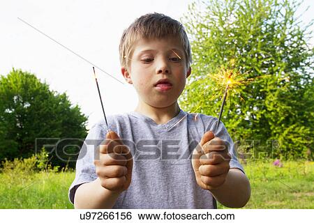 Portrait of boy holding sparklers View Large Photo Image Stock Photograph - Portrait of boy holding sparklers. Fotosearch