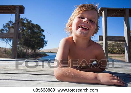 Portrait of boy on pier, smiling View Large Photo Image Stock Photo - Portrait of boy on pier, smiling. Fotosearch