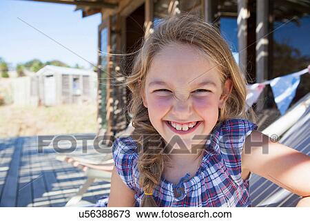 Stock Image - Portrait of girl wearing checked blouse, smiling. Fotosearch
