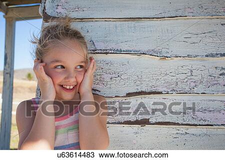 Portrait of girl with finger in ears by clapboard cabin View Large Photo Image Stock Image - Portrait of girl with finger in ears by clapboard cabin. Fotosearch