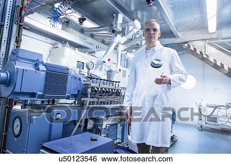 Stock Photograph - Portrait of lab technician holding empty glass jar. Fotosearch