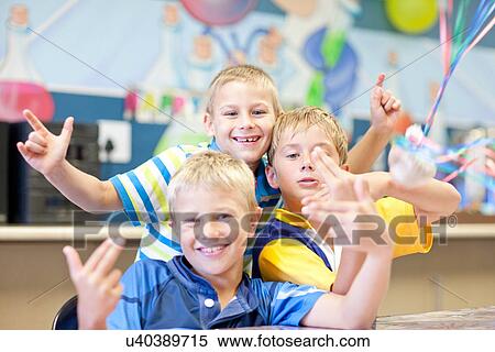Stock Photography - Portrait of three boys gesturing toward camera. Fotosearch