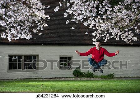 Picture - Portrait of young man meditating on a slackline. Fotosearch