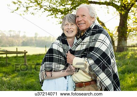 Senior couple wrapped in shawl together View Large Photo Image Stock Image - Senior couple wrapped in shawl together. Fotosearch