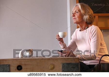 Senior woman holding coffee cup and mobile phone View Large Photo Image Stock Photography - Senior woman holding coffee cup and mobile phone. Fotosearch