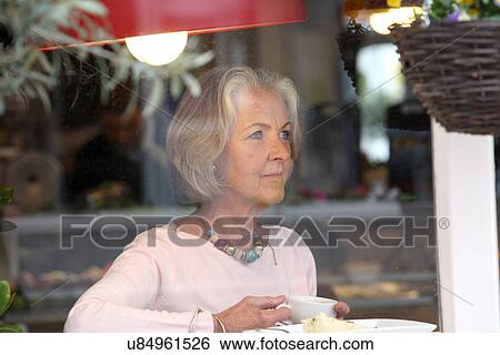 Senior woman holding coffee cup in cafe View Large Photo Image Stock Photograph - Senior woman holding coffee cup in cafe. Fotosearch