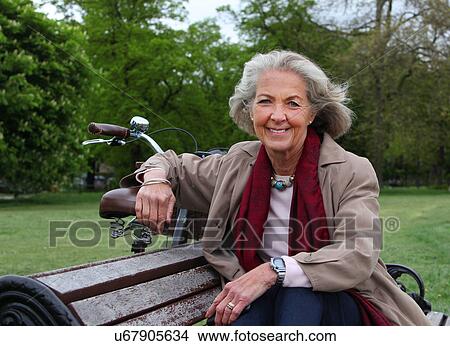 Picture - Senior woman sitting on park bench, portrait. Fotosearch