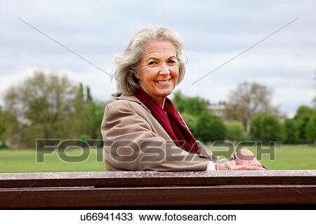 Senior woman sitting on park bench, portrait View Large Photo Image Stock Image - Senior woman sitting on park bench, portrait. Fotosearch