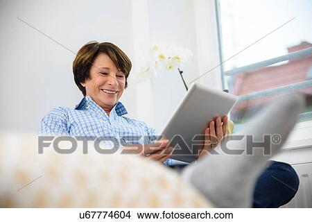Picture - Senior woman using digital tablet. Fotosearch