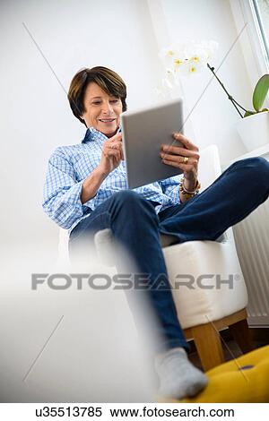 Stock Photography - Senior woman using digital tablet. Fotosearch