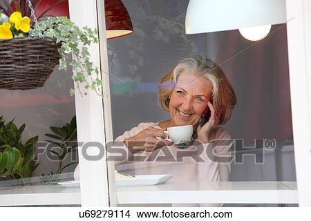 Senior woman using mobile phone in cafe View Large Photo Image Picture - Senior woman using mobile phone in cafe. Fotosearch