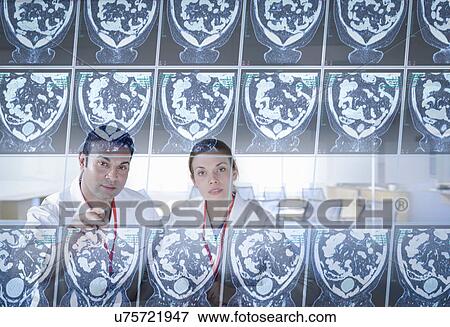 Stock Photo - Surgeons inspecting computed tomography (CT) scans on screen. Fotosearch