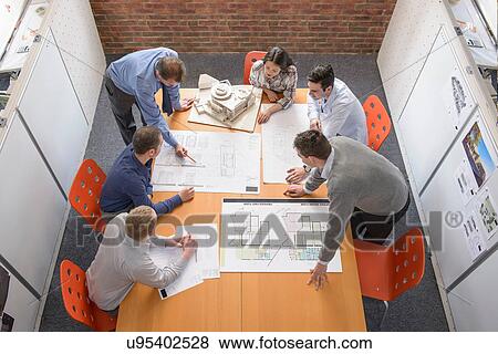 Stock Photo - Team of architects discussing plans in meeting room. Fotosearch