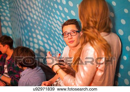 Teenage boy looking up at teenage girl, friends in background View Large Photo Image Stock Photo - Teenage boy looking up at teenage girl, friends in background. Fotosearch