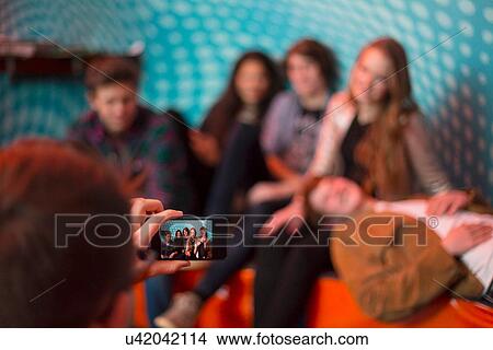 Teenage boy taking photo of group of friends using smartphone View Large Photo Image Picture - Teenage boy taking photo of group of friends using smartphone. Fotosearch