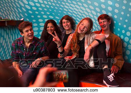 Teenage boy taking photo of group of friends using smartphone View Large Photo Image Stock Image - Teenage boy taking photo of group of friends using smartphone. Fotosearch