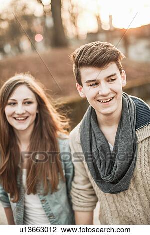 Teenage couple standing in park View Large Photo Image Stock Image - Teenage couple standing in park. Fotosearch