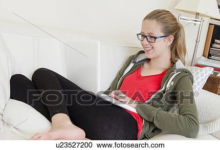 Teenage girl using laptop on sofa, smiling View Large Photo Image Stock Image - Teenage girl using laptop on sofa, smiling. Fotosearch