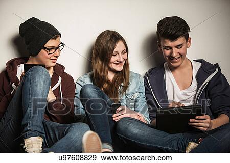 Stock Photo - Teenagers using digital tablet. Fotosearch