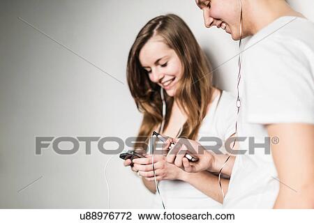 Stock Image - Teenagers using smartphones. Fotosearch