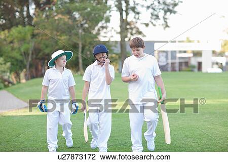 Three boys walking on cricket pitch View Large Photo Image Stock Image - Three boys walking on cricket pitch. Fotosearch