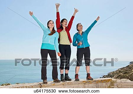 Three female friends waving from wall at coast View Large Photo Image Stock Image - Three female friends waving from wall at coast. Fotosearch