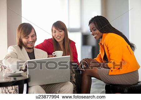 Picture - Three young adults using laptop. Fotosearch