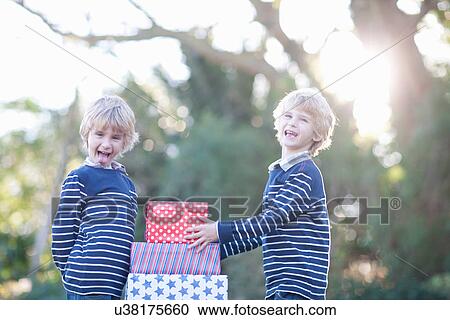 Stock Image - Twin boys with birthday gifts. Fotosearch