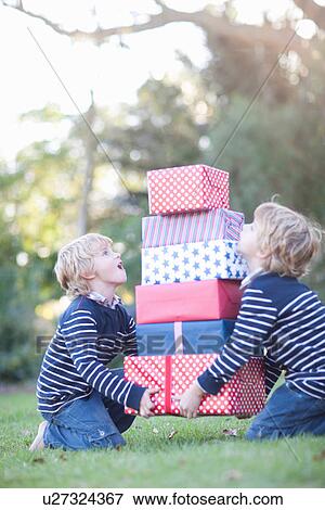 Stock Photo - Twin boys with birthday gifts. Fotosearch