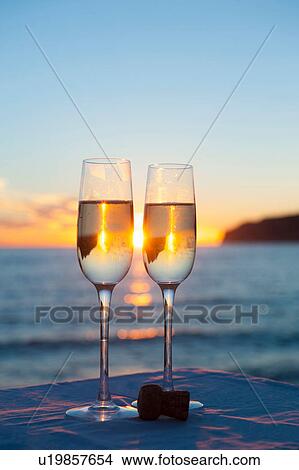 Picture - Two wine glasses with sea in background. Fotosearch