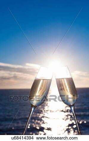 Picture - Two wine glasses with sea in background. Fotosearch