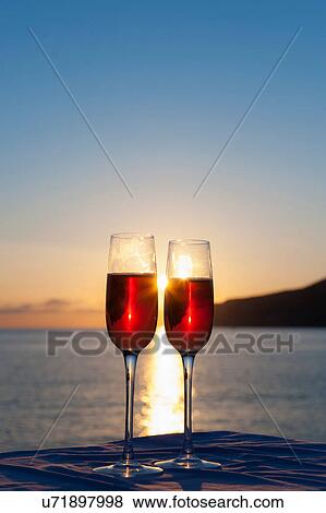 Two wine glasses with sea in background View Large Photo Image Stock Photo - Two wine glasses with sea in background. Fotosearch