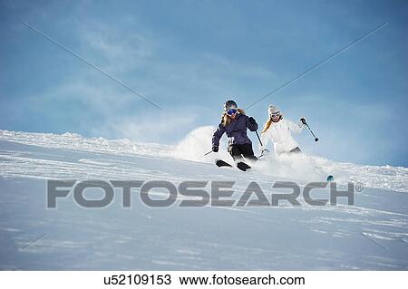 Stock Image - Two women skiing. Fotosearch