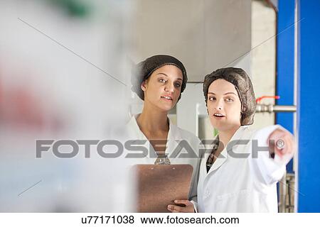 Two women working in olive processing plant View Large Photo Image Stock Photo - Two women working in olive processing plant. Fotosearch