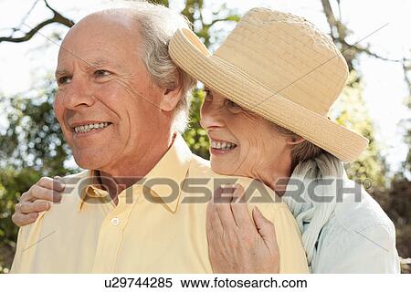 Stock Photography - Wife hugging husband from behind. Fotosearch