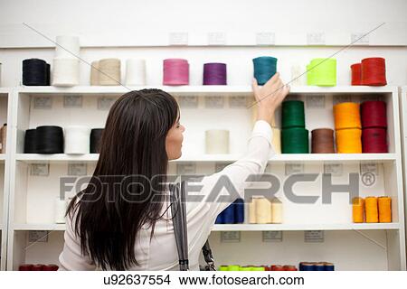 Woman choosing spool of thread in store View Large Photo Image Picture - Woman choosing spool of thread in store. Fotosearch