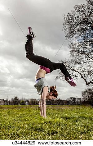 Woman doing handstand with legs apart View Large Photo Image Stock Photo - Woman doing handstand with legs apart. Fotosearch