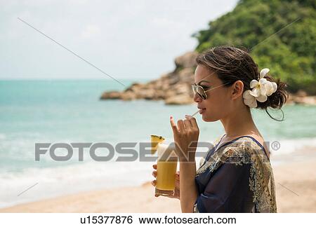 Woman drinking on beach, Banyon Tree Resort, Ko Samui, Thailand View Large Photo Image Stock Photograph - Woman drinking on beach, Banyon Tree Resort, Ko Samui, Thailand. Fotosearch