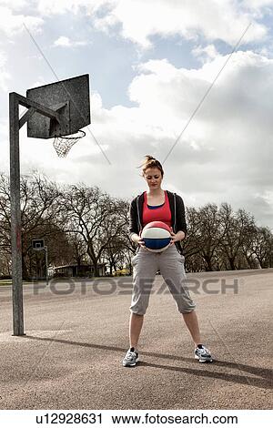Woman holding ball at netball court View Large Photo Image Stock Image - Woman holding ball at netball court. Fotosearch