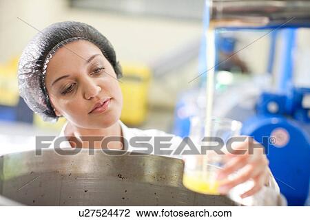 Woman holding beaker of olive oil in olive processing plant View Large Photo Image Stock Image - Woman holding beaker of olive oil in olive processing plant. Fotosearch