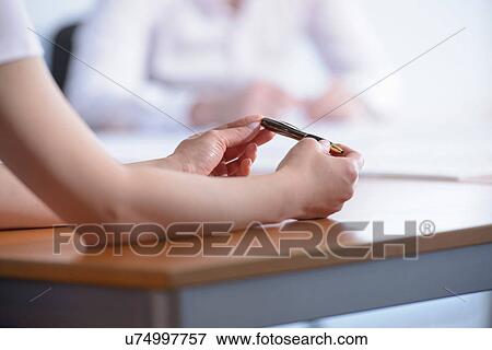Stock Photo - Woman holding pen in business meeting, close up. Fotosearch