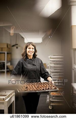 Woman holding tray with chocolate View Large Photo Image Stock Photo - Woman holding tray with chocolate. Fotosearch